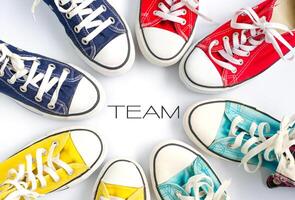 multicolore scarpe da ginnastica su bianca sfondo e parola squadra concetto squadra opera foto