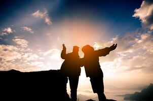 il silhouette di il turisti siamo contento per godere montagna scenario nel il mattina. foto