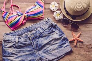 bellezza colorato bikini e Accessori su di legno pavimento per viaggio su estate foto