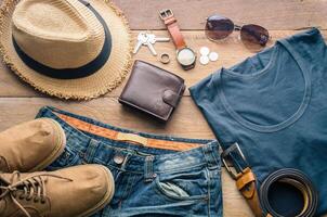 Accessori e abbigliamento per viaggio su un' di legno pavimento - vita stile foto