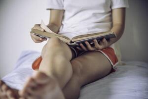 adolescenti leggere libri su il letto nel il Camera da letto. foto