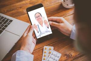 il del paziente punto di vista consultare con il medico attraverso sociale media come come computer portatile, smartphone, Quasi. il opera per casa concetto di medici e pazienti. foto