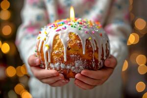 ai generato bambino Tenere nel mani Pasqua torta kulich decorato con bianca gocciolante glassatura, colorato spruzzatori e ardente candela. sfocato sfondo. ideale per vacanza Pasqua contenuto, foto