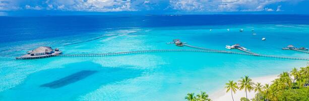 bellissimo paradiso delle Maldive. paesaggio di viaggio aereo tropicale, paesaggio marino con ponte di legno, ville sull'acqua, incredibile spiaggia con cielo di sabbia di mare, natura tropicale dell'isola. vacanza estiva destinazione turismo esotico foto