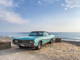 sorprendente tiro di un' classico auto parcheggiata su il spiaggia foto