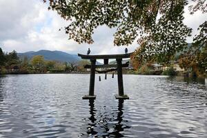 antico torii a kinrin lago nel autunno. esso è un' famoso punto di riferimento di yufuin nel oita quartiere, Giappone. foto