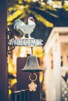 Vintage ▾ di legno cartello benvenuto con un' campana sotto il cartello su porta di bar foto