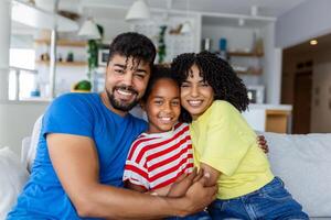 amorevole diverso genitori trascorrere tempo con poco adorabile figlia avere divertimento insieme a moderno casa sorridente ridendo, vicino su. contento multietnico famiglia concetto foto