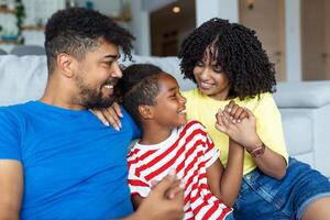 amorevole diverso genitori trascorrere tempo con poco adorabile figlia avere divertimento insieme a moderno casa sorridente ridendo, vicino su. contento multietnico famiglia concetto foto