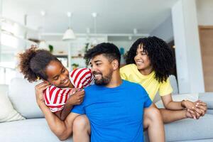 amorevole diverso genitori trascorrere tempo con poco adorabile figlia avere divertimento insieme a moderno casa sorridente ridendo, vicino su. contento multietnico famiglia concetto foto