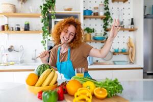 divertente bellissimo donna cantando in spatola, cucinando nel moderno cucina, Tenere spatola come microfono, ballare, ascoltando per musica, giocoso ragazza avendo divertimento con stoviglie, preparazione cibo. foto