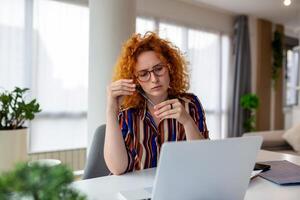 donna d'affari seduta a sua scrivania Lavorando su il computer portatile computer nel grande città ufficio. fiducioso sociale media strategia manager Piano dirompente e-commerce campagna foto