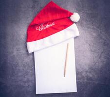 Santa cappello e carta, matita scrittura concetto foto