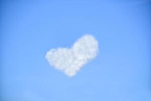 bianca nuvole nel il forma di cuore su un' blu cielo foto