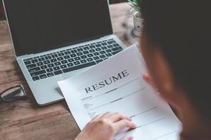 persone siamo rivedere lavoro applicazioni prima Riempimento su loro curriculum vitae su il lavoro applicazione modulo nel ordine per applicare per un' lavoro a un' azienda. foto