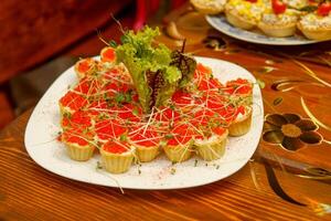 tartellette con cagliata formaggio e rosso caviale decorato con erbe aromatiche su un' piatto foto