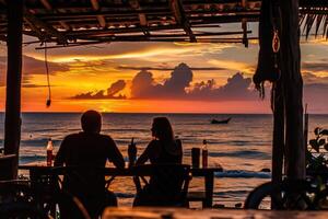 ai generato un' coppia bevande vino nel un' bar contro il fondale di un' tramonto a mare. sagome di persone foto