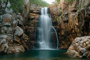 ai generato sereno Immagine cattura pittoresco cascata fluente giù roccioso scogliera. il cascata è circondato di frastagliato rocce e verde, indicando naturale, possibilmente a distanza Posizione ai generato foto