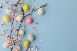 ai generato contento Pasqua, colorato Pasqua cioccolato uova con ciliegia fiori piatto posare su blu sfondo. elegante tenero primavera modello con spazio per testo. saluto carta o bandiera foto