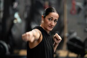 femmina pugile lancio un' colpo mentre shadowboxing nel il Palestra foto