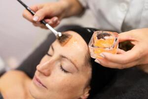 irriconoscibile estetista l'applicazione idratante trattamento su cliente viso foto