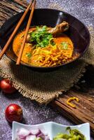 khao così io ricetta khao soi, Khao così io kai, tailandese tagliatelle khao così io, pollo curry con stagionatura su di legno pavimento, settentrionale tailandese cibo concetto. lanna cibo foto