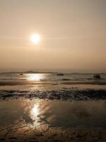 tramonto su il spiaggia nel vai, India. il sole è ambientazione al di sopra di il oceano. foto