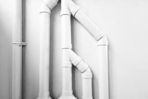 bianca tubi su calcestruzzo parete con leggero fascio e ombra. foto