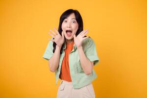energico giovane asiatico donna nel sua 30s indossare un' verde e arancia camicia appassionatamente urlando con eccitazione. isolato su un' giallo sfondo, che rappresentano il concetto di sconto shopping promozione. foto