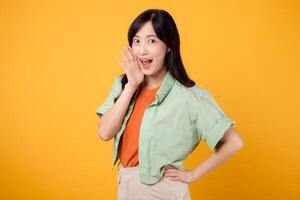 vivace Immagine giovane asiatico donna 30s indossare verde camicia su arancia sfondo, energicamente urlando con eccitazione. Esplorare il concetto di sconto shopping promozione con Questo dinamico immagine. foto