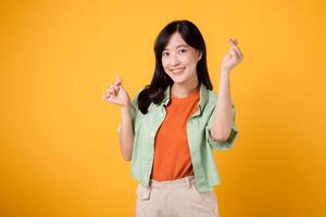 calore di affetto e felicità con giovane asiatico donna anni '30, vestito nel un arancia camicia e verde Maglione. sua mini cuore gesto e dolce Sorridi esprimere un' profondo Messaggio attraverso corpo linguaggio. foto