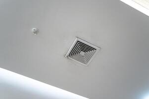 soffitto montato cassetta genere aria condizionatore e moderno lampada leggero su bianca soffitto. condotto aria condizionatore per casa, sala o ufficio. foto