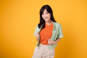 gioia di benessere con un' allegro giovane asiatico donna nel sua 30s indossare un arancia camicia. contento mente benessere gesto su un' giallo sfondo, cattura un' felicità ritratto di interno beatitudine. foto