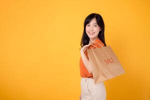 sorridente asiatico donna acquirente con borse, godendo un' vendita e aggiungendo nuovo moda trova per sua collezione. alla moda Al dettaglio terapia. foto