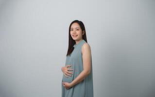 donna incinta che tiene sulla sua pancia facendo la mano a forma di cuore isolato su sfondo bianco. concetto di gravidanza mamma madre di famiglia. foto