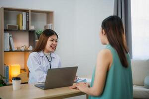 asiatico professionale donna medico parlando consultare per assistenza sanitaria soluzione per sua paziente o incinta donna nel visita medica camera a ospedale o clinica. foto