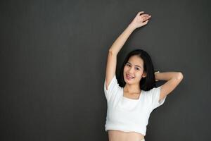 ritratto di asiatico giovane donna nel vuoto bianca maglietta su nero sfondo foto