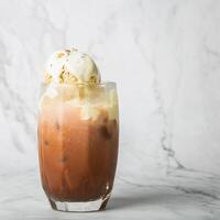 ghiacciato cacao su superiore di vaniglia ghiaccio crema nel chiaro bicchiere su marmo foto