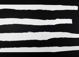 strappato vuoto bianca carta strisce contro un' nero sfondo foto