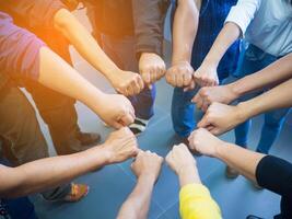 avvicinamento di molti persone mettendo loro pugni insieme come un' simbolo cerchio di unità. concetto di unità e lavoro di squadra. foto