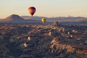 caldo aria Palloncino volo nel goreme nel tacchino durante Alba. cavalcata nel un' caldo aria Palloncino, il maggior parte popolare attività nel cappadocia. romantico e famoso viaggio destinazione. foto