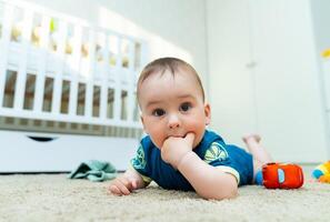 un' tranquillo, calmo bambino riposo su il pavimento foto