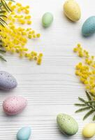 colorato Pasqua uova e mimosa fiori su di legno tavolo. foto