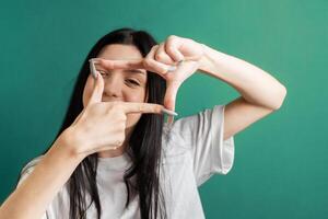 giovane ragazza Spettacoli il telaio con sua mani foto