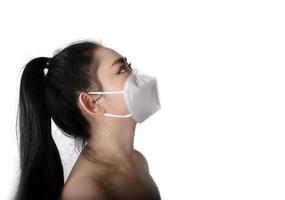 vista laterale della giovane donna asiatica che indossa una maschera respiratore n95 per proteggere dalle malattie respiratorie trasmesse dall'aria come l'influenza covid-19 coronavirus ebola pm2.5 polvere e smog, concetto di infezione da virus di sicurezza foto