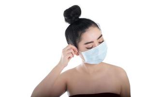 bella giovane donna asiatica che indossa una maschera medica per proteggersi dalle malattie respiratorie trasmesse dall'aria come l'influenza covid-19 pm2.5 polvere e smog, concetto di infezione da virus della sicurezza delle donne, guarda la fotocamera foto