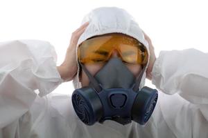 la donna si sente affaticata in un abbigliamento protettivo chimico e maschera antigas con occhiali gialli su sfondo bianco isolato, scienziate in tuta di sicurezza, concetto di infezione da virus covid-19 di sicurezza