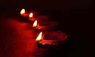 felice diwali - lampade diya accese durante la celebrazione del diwali. lanterne colorate e decorate si accendono di notte in questa occasione con rangoli di fiori, dolci e regali. foto