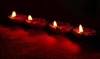 felice diwali - lampade diya accese durante la celebrazione del diwali. lanterne colorate e decorate si accendono di notte in questa occasione con rangoli di fiori, dolci e regali. foto