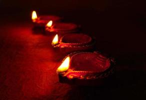 felice diwali - lampade diya accese durante la celebrazione del diwali. lanterne colorate e decorate si accendono di notte in questa occasione con rangoli di fiori, dolci e regali. foto